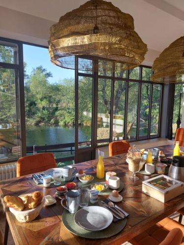 SauveにあるLa Magnanerie d'Hôtes ,le jardin secretのダイニングルーム(水辺の景色を望むダイニングテーブル付)