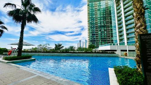 a large swimming pool with a palm tree and buildings at Address JBR Sea View, Jumeirah Beach Residence, Dubai Marina - Mint Stay in Dubai