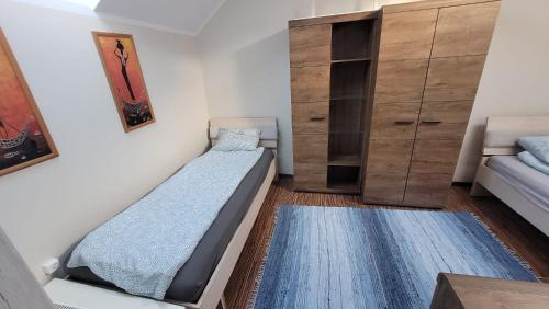 a bedroom with two beds and a closet at Poddasze kamienica Włocławek centrum in Włocławek