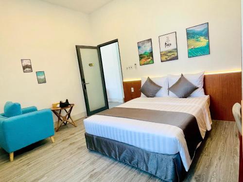 a hotel room with a bed and a blue chair at Khem Beach serviced apartment in Phú Quốc