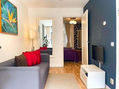 a living room with a couch and a tv at Artist House Amsterdam in Amsterdam