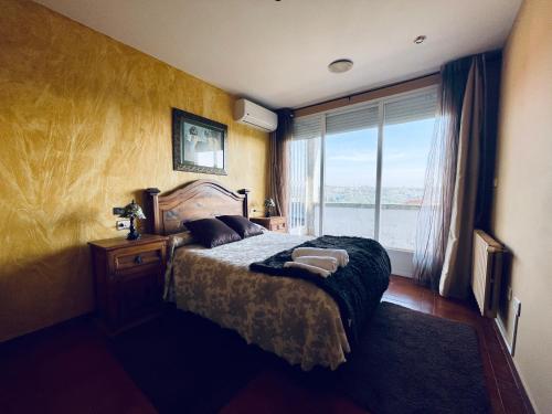 a bedroom with a bed and a large window at O Souto de Monteasnal in Ourense