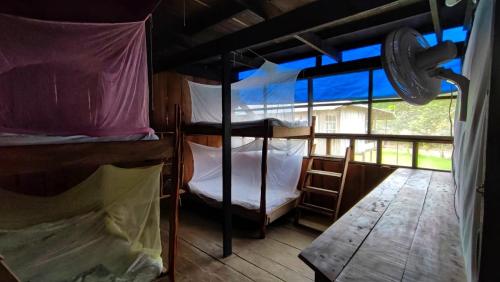 a room with two bunk beds and a wooden floor at Hospedaje y tours Reina Arriera amazonas colombia in Macedonia