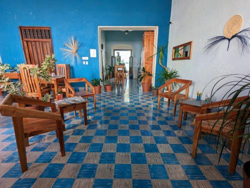 a room with wooden chairs and tables and blue walls at Casa Aguazul in Campeche