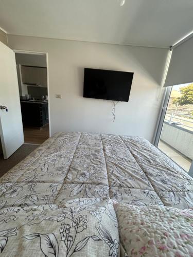 sypialnia z łóżkiem z telewizorem na ścianie w obiekcie Departamento arriendo Diario Factura Empresas w mieście Talcahuano