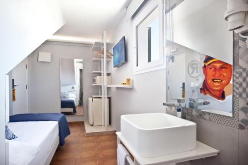 a bathroom with a bed and a sink in a room at Ryans La Marina in Ibiza Town