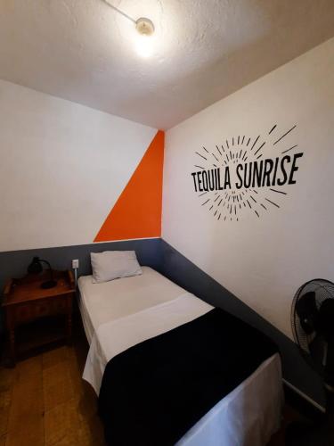 a room with a bed and a sign that reads tequila sunrise at Tequila Sunrise Hostel in Guatemala