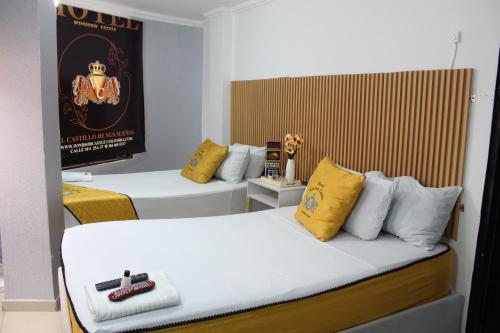a room with two beds with yellow and white pillows at Hotel WC in Bogotá