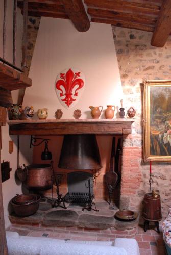 a room with a fireplace with pots and pans at Borgo San Gusmè in San Gusmè