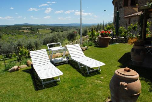 a group of chairs sitting in the grass at Borgo San Gusmè in San Gusmè