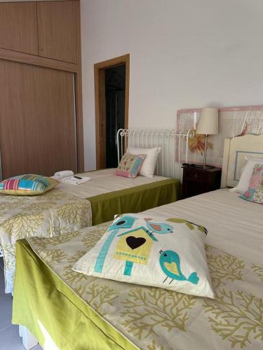 a hotel room with two beds with a bird on the pillow at 3 Marias São Sebastião in Lousa