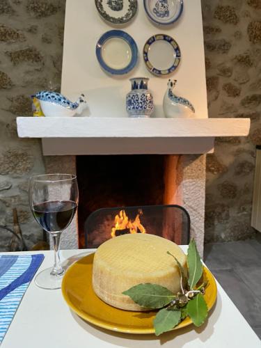 a cake on a yellow plate on a table with a fireplace at 3 Marias São Sebastião in Lousa