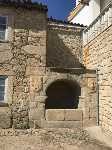 a brick building with an archway on the side of it at 3 Marias São Sebastião in Lousa