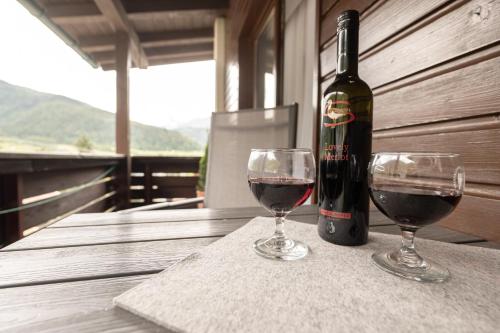 a bottle of wine sitting on a table with two glasses at Senner Appartements in Umhausen