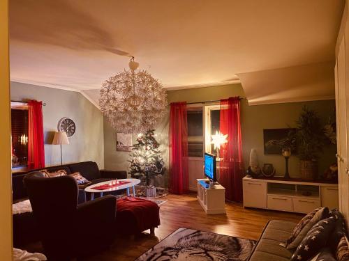 uma sala de estar com um sofá e um lustre em Vindsvåning Höga Kusten em Kramfors