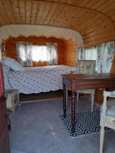 um quarto com uma cama e uma mesa num quarto em le clos des epinettes em Angé