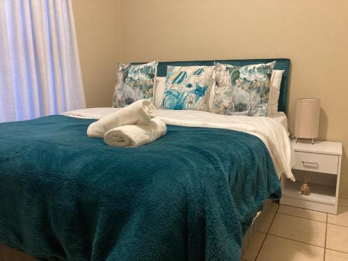 a bed with two towels on top of it at Sparrow Apartment in Johannesburg