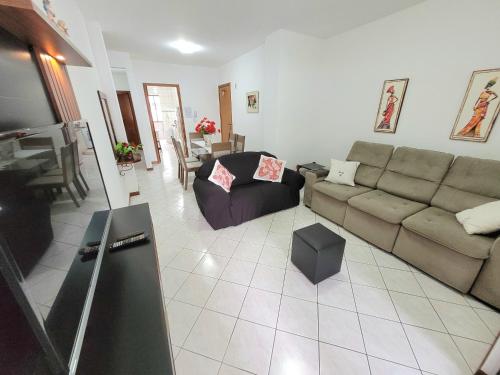 ein Wohnzimmer mit einem Sofa und einem Tisch in der Unterkunft Apartamento 200 metros da praia 03 quartos com ar condicionado - Meia Praia - Itapema in Itapema