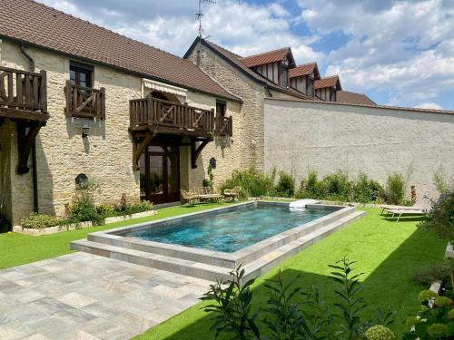 a swimming pool in the yard of a house at Le Clos Papillon in Corcelles-les-Monts