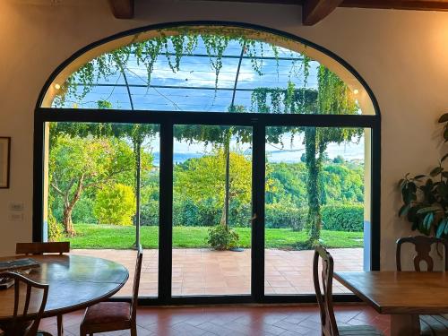 an arched door leading to a patio with a table and chairs at Tenuta Massabò in San Casciano in Val di Pesa