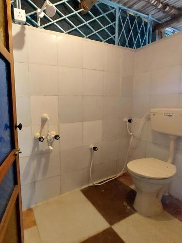 a bathroom with a toilet in a room at Open house in Auroville
