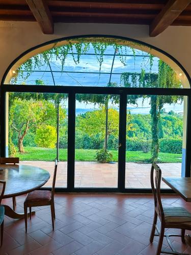 a large glass window in a room with a table and chairs at Tenuta Massabò in San Casciano in Val di Pesa