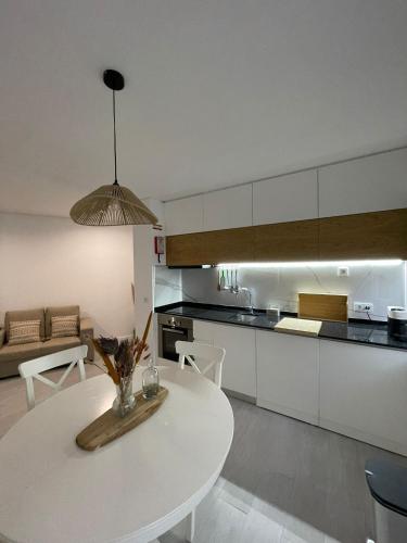 a kitchen with a white table and a white counter top at Marinho's Oporto Apartments II in Porto