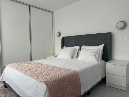 a bedroom with a large bed with white sheets and pillows at Marinho's Oporto Apartments II in Porto