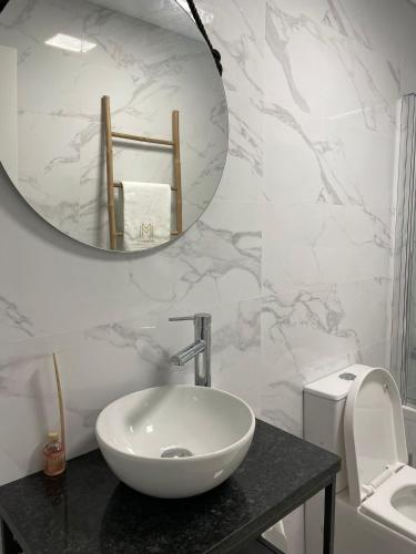 a bathroom with a white sink and a mirror at Marinho's Oporto Apartments II in Porto