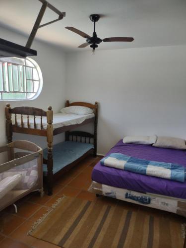 a bedroom with two bunk beds and a ceiling fan at Casa com piscina em Bertioga in Bertioga