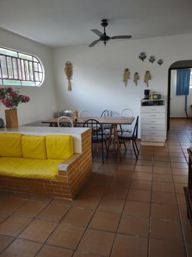 a living room with a yellow couch and a table at Casa com piscina em Bertioga in Bertioga