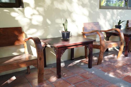 a table with two chairs and a potted plant on it at Elegant Lanna Guesthouse in Chiang Mai