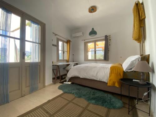 a bedroom with a bed and a desk and a window at Maria’s Cottage House in Kalymnos