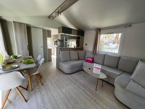 塞里尼昂的住宿－Mobil Home 2CH Bien Equipé Valras-Plage，客厅配有沙发和桌子