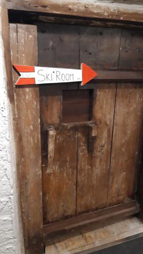 a sign with an arrow on top of a wooden door at Casa Trettel in Tesero