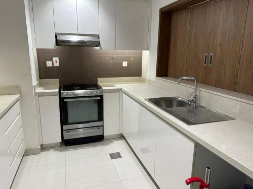 a kitchen with a sink and a stove at Sherina Plaza 2 Flat 103 in Dubai