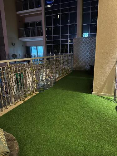 a room with green grass in front of a building at Sherina Plaza 2 Flat 103 in Dubai
