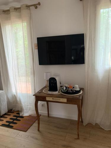 uma sala de estar com uma mesa e uma televisão na parede em The home Privacy em Marselha