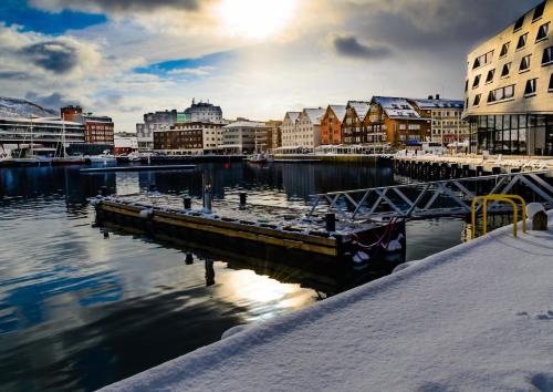 a view of a harbor with buildings and the water at Jolly Good Times Sailing in Tromsø