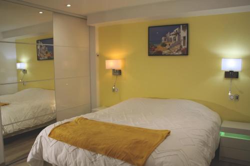 a bedroom with two beds and a mirror at maison canoa in Argenteuil