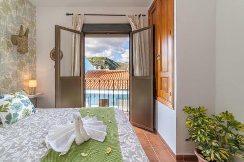 a bedroom with a bed with a view of a balcony at la casa del bosque in Júzcar
