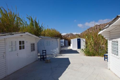 a couple of small white buildings in a driveway at Paradise Beach Camping - Adults Only in Paradise Beach