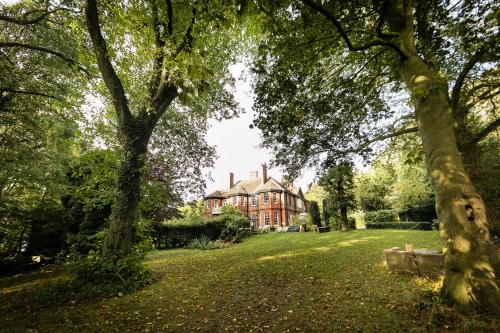 a house in the middle of a yard with trees at Hillthorpe Manor by Maison Parfaite - Large Country House with Hot Tub in Pontefract