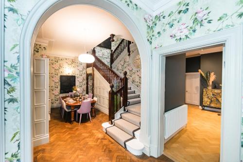 an archway leads into a dining room with a table at Hillthorpe Manor by Maison Parfaite - Large Country House with Hot Tub in Pontefract