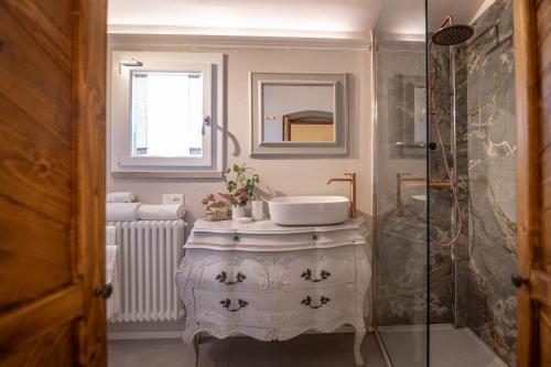 een witte badkamer met een wastafel en een douche bij San Michele al Castello in Castiglion Fiorentino