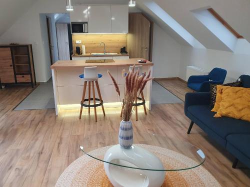 a living room with a vase on a glass table at M10 Apartman in Pécs