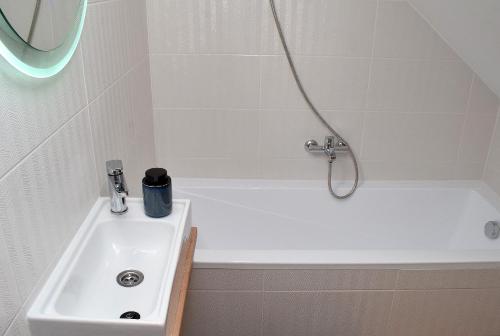 La salle de bains est pourvue d'un lavabo et d'une baignoire. dans l'établissement M10 Apartman, à Pécs