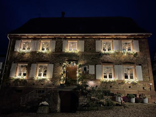 an old brick house with christmas lights on it at chambres d'hotes chez Linda Stéphane le passé composé 