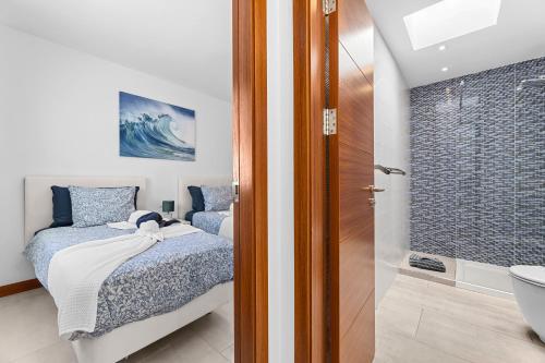 a bedroom with a bed and a bathroom with a shower at Villa Atlántica - Heated pool in Playa Blanca in Playa Blanca