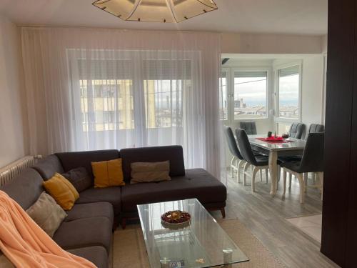 Dielli Apartment New في بريشتيني: غرفة معيشة بها أريكة وطاولة
